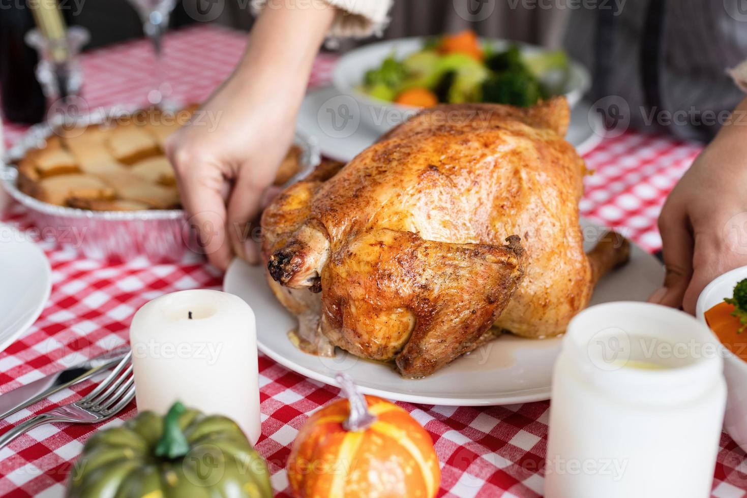 mujer preparando pavo para la cena de acción de gracias en la cocina de casa foto