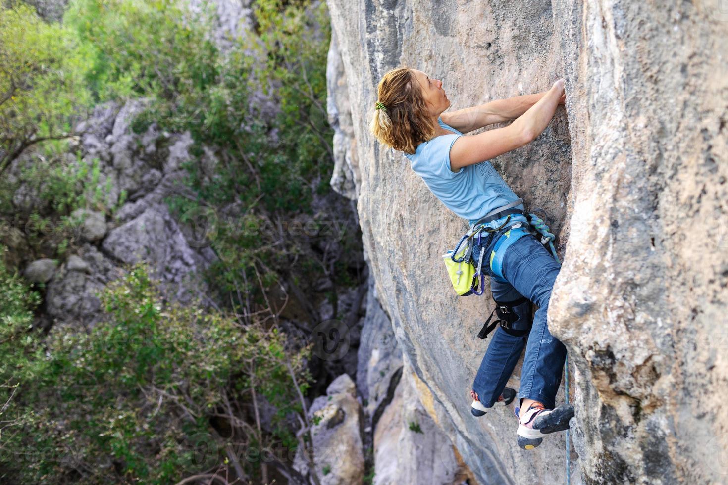 A woman climbs a rock photo