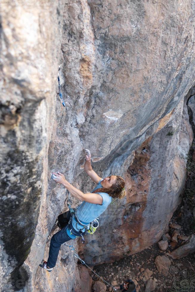 A woman climbs a rock photo