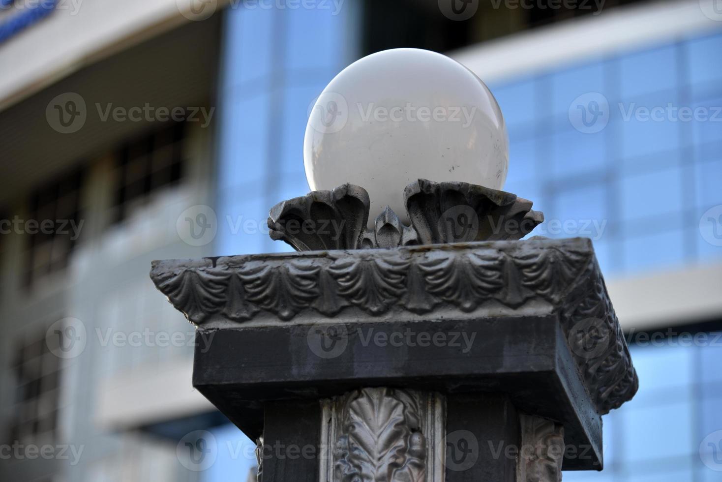 Iron fence with pins and lanterns in the city photo