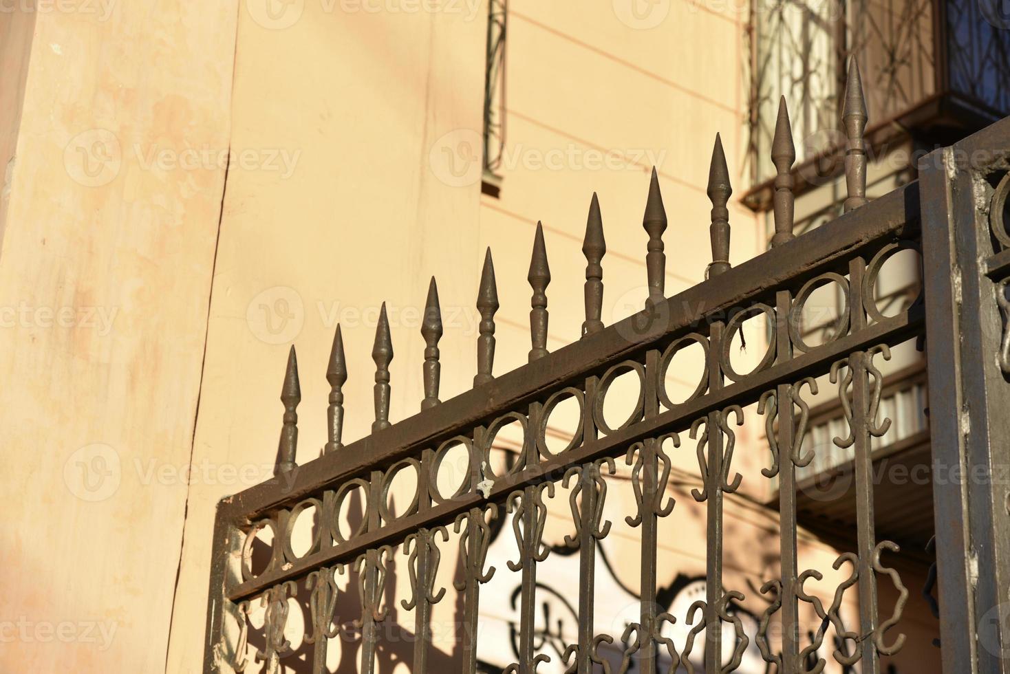 Iron fence with pins and lanterns in the city photo