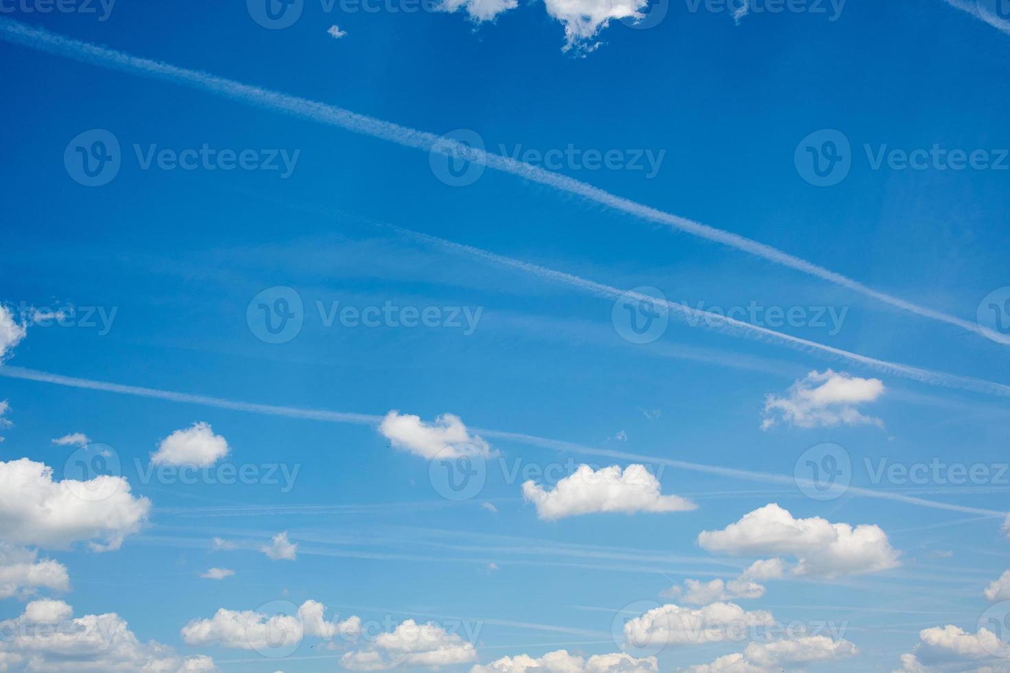 contrails in the blue cloudy sky photo