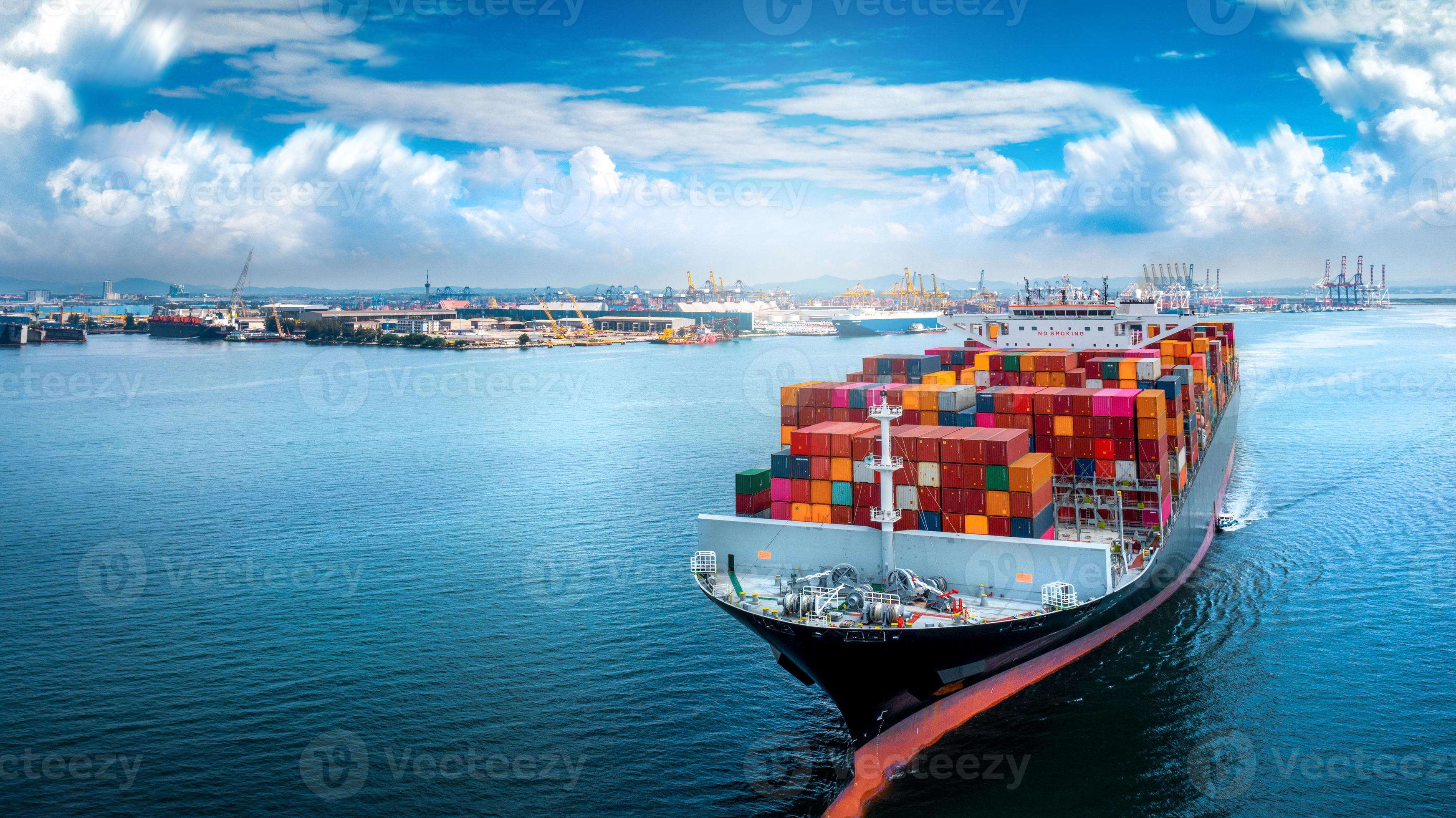 Aerial side view of cargo ship carrying container and running for