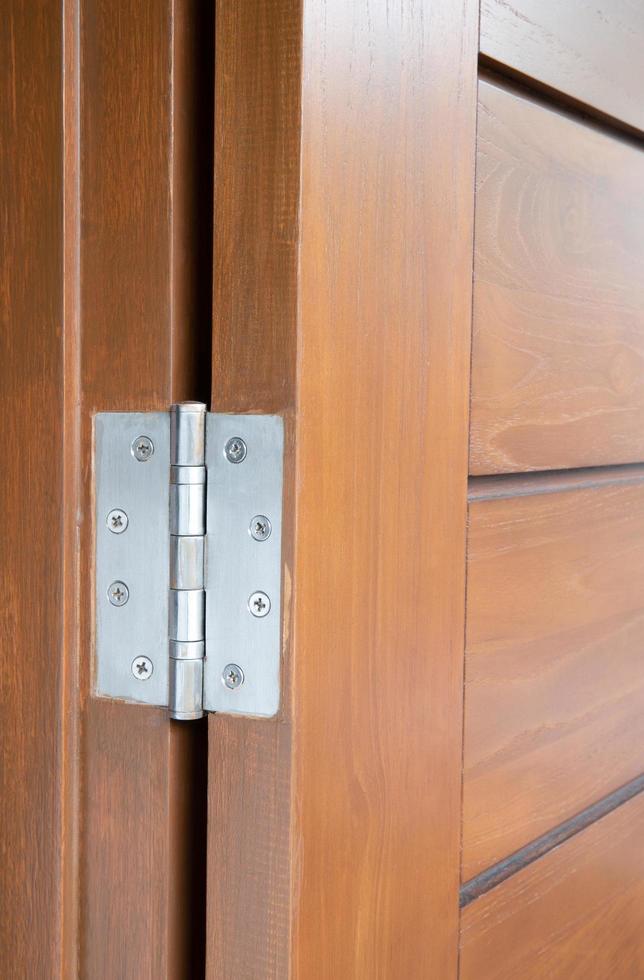 Stainless door hinge installed on wooden swing door photo