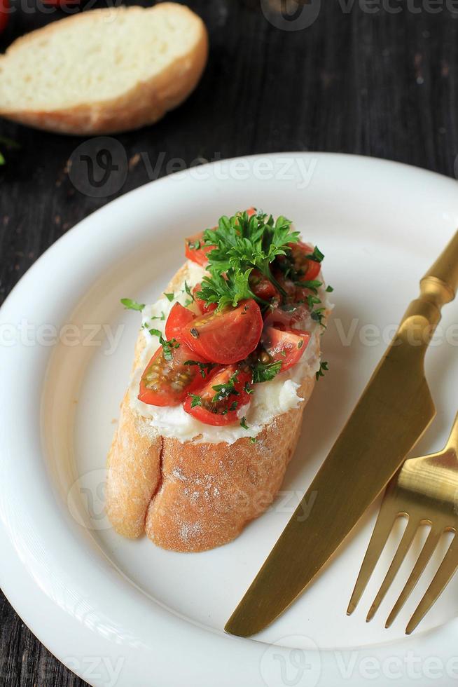 bruschetta de tomate, aperitivos italianos crujientes, rebanadas de bruschetta de baguette tostado con tomate, albahaca y aceite de oliva foto