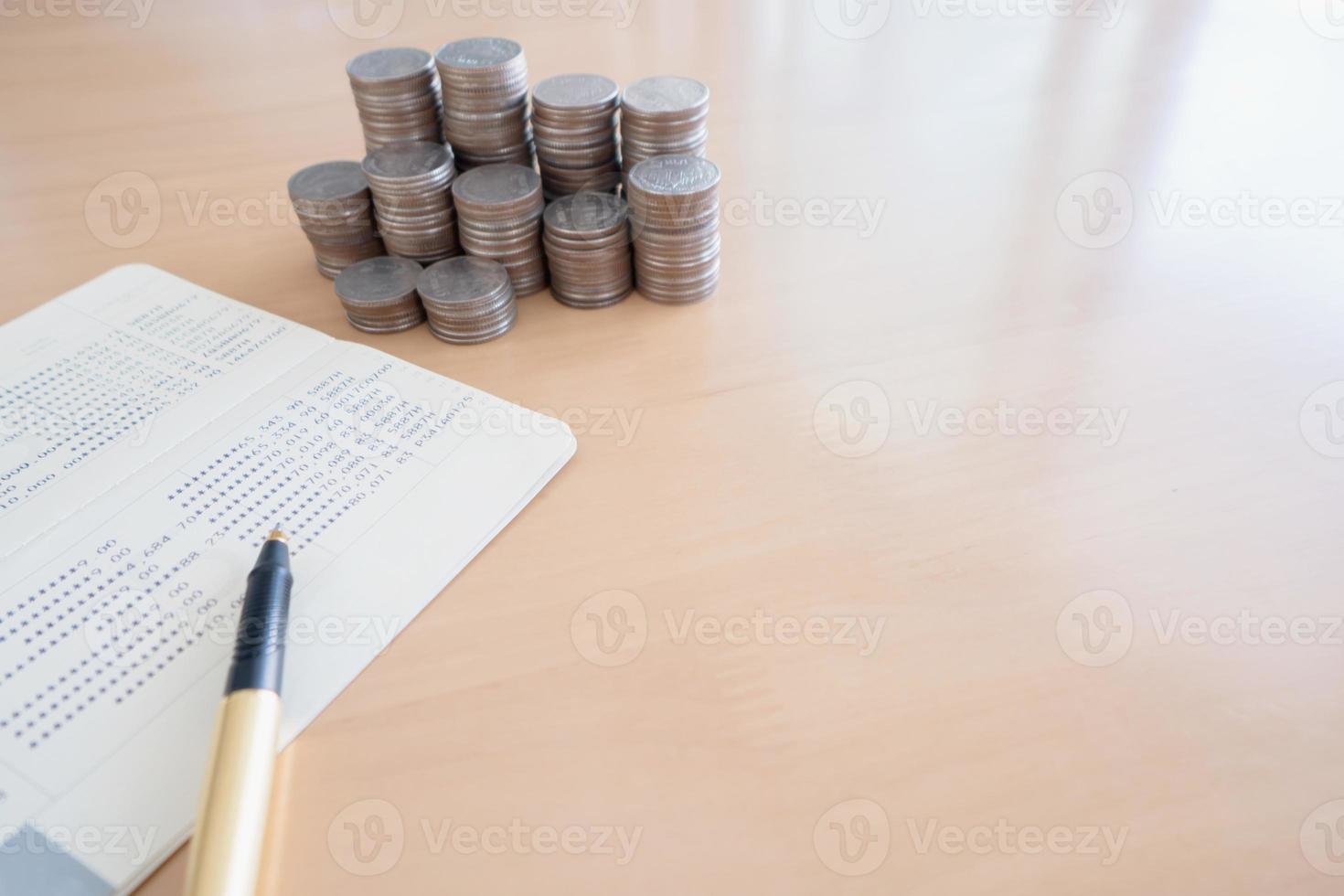 monedas y bolígrafo en la libreta de la cuenta de ahorros foto