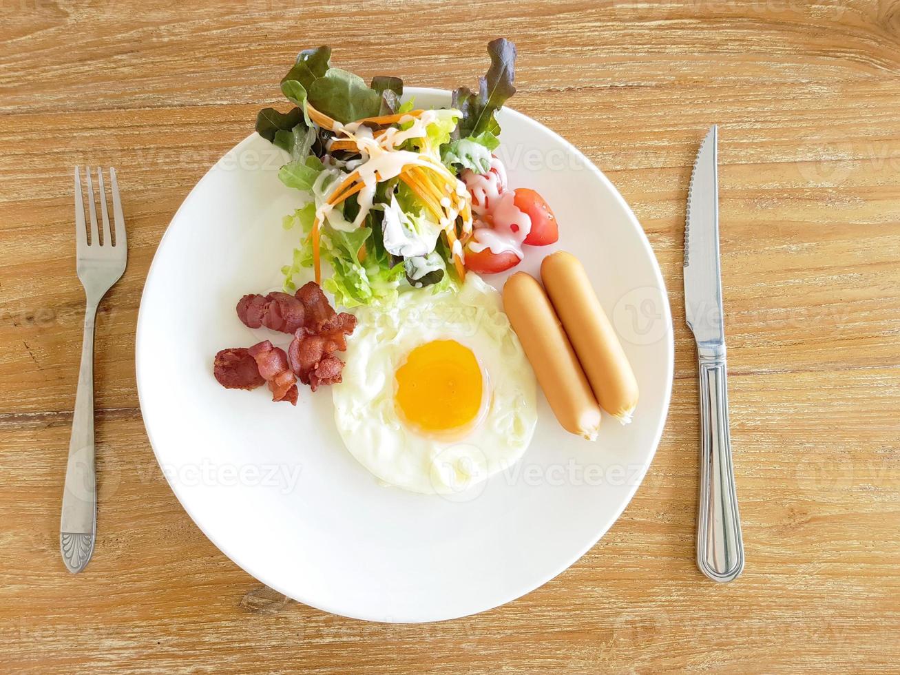 A closeup of eggs, bacon, ham, and sausage on top of toast photo