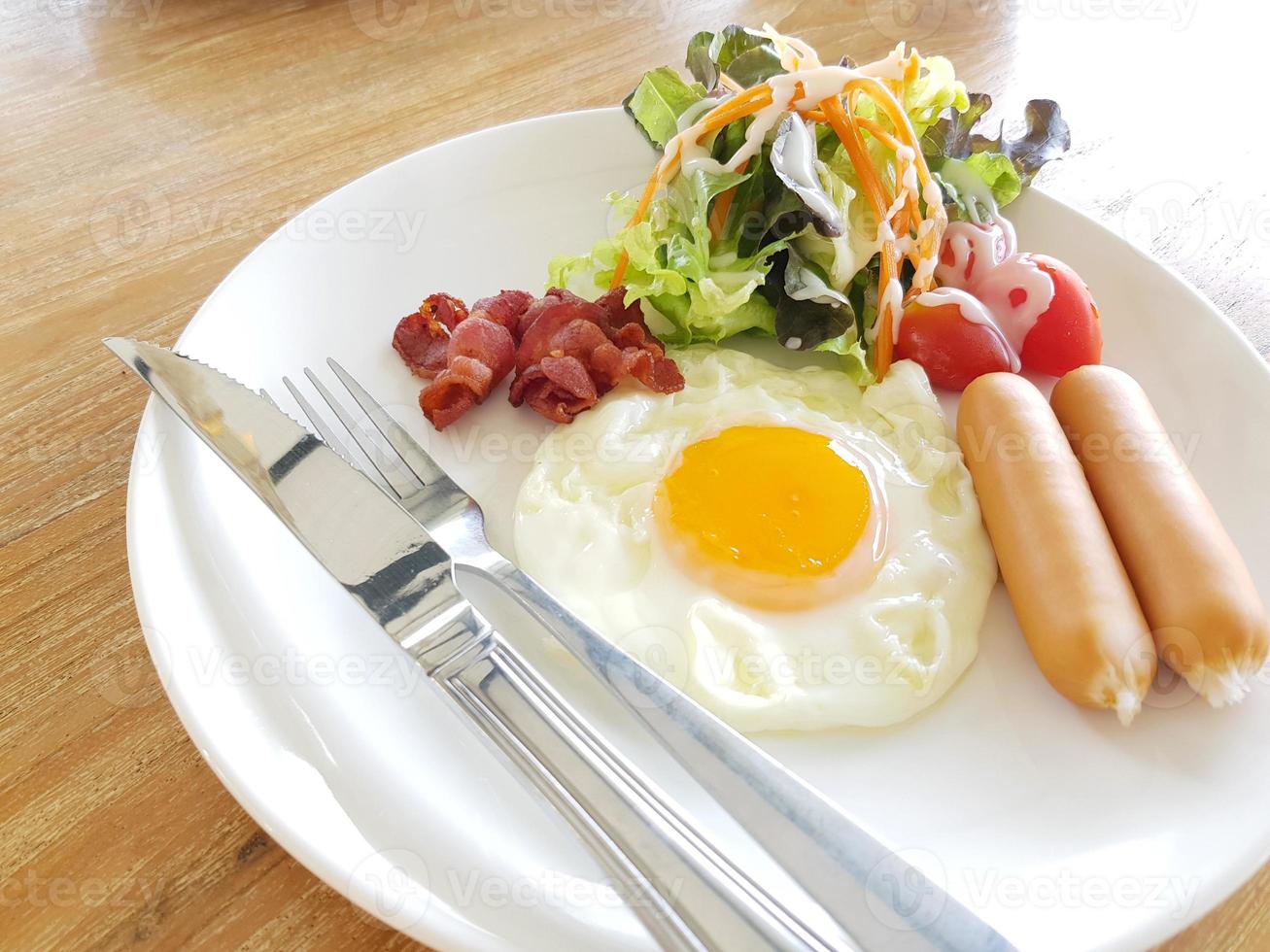 A closeup of eggs, bacon, ham, and sausage on top of toast photo