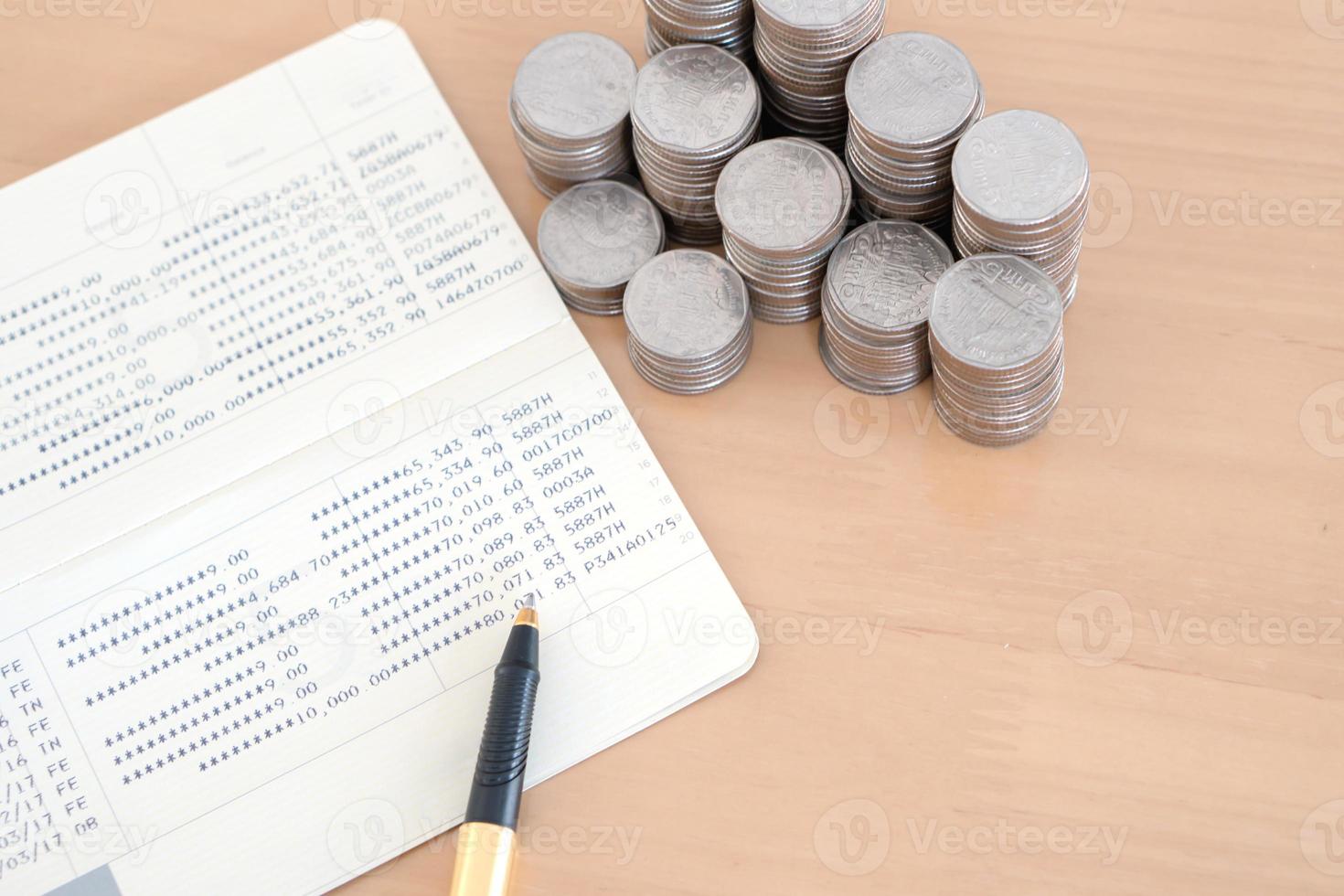 monedas y bolígrafo en la libreta de la cuenta de ahorros foto