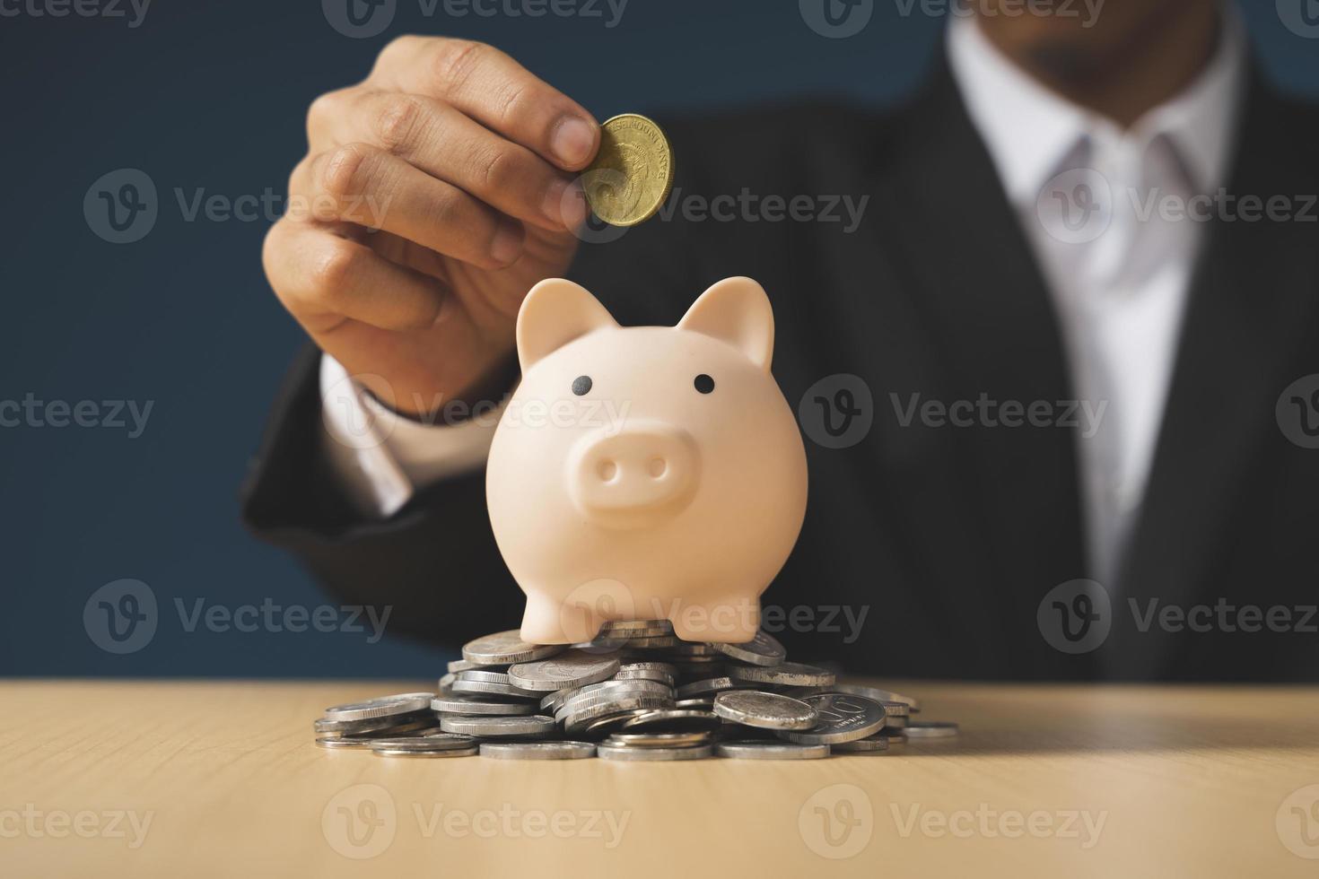 hand putting money to piggy bank, saving money concept photo