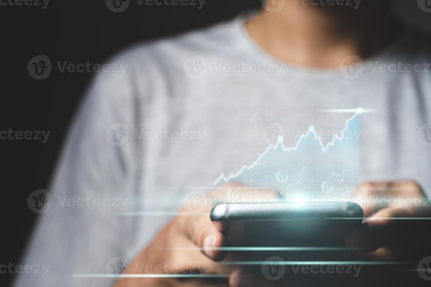 Man using mobile phone checking stock market graph report via mobile apps photo