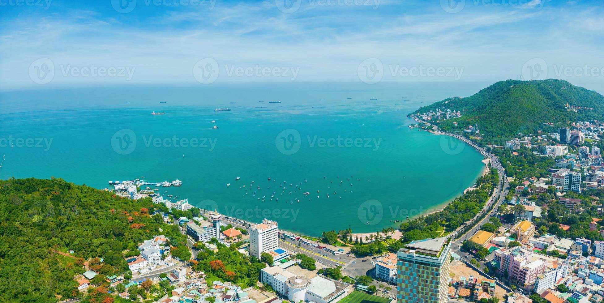 Vung Tau city aerial view with beautiful sunset and so many boats. Panoramic coastal Vung Tau view from above, with waves, coastline, streets, coconut trees and Tao Phung mountain in Vietnam. photo