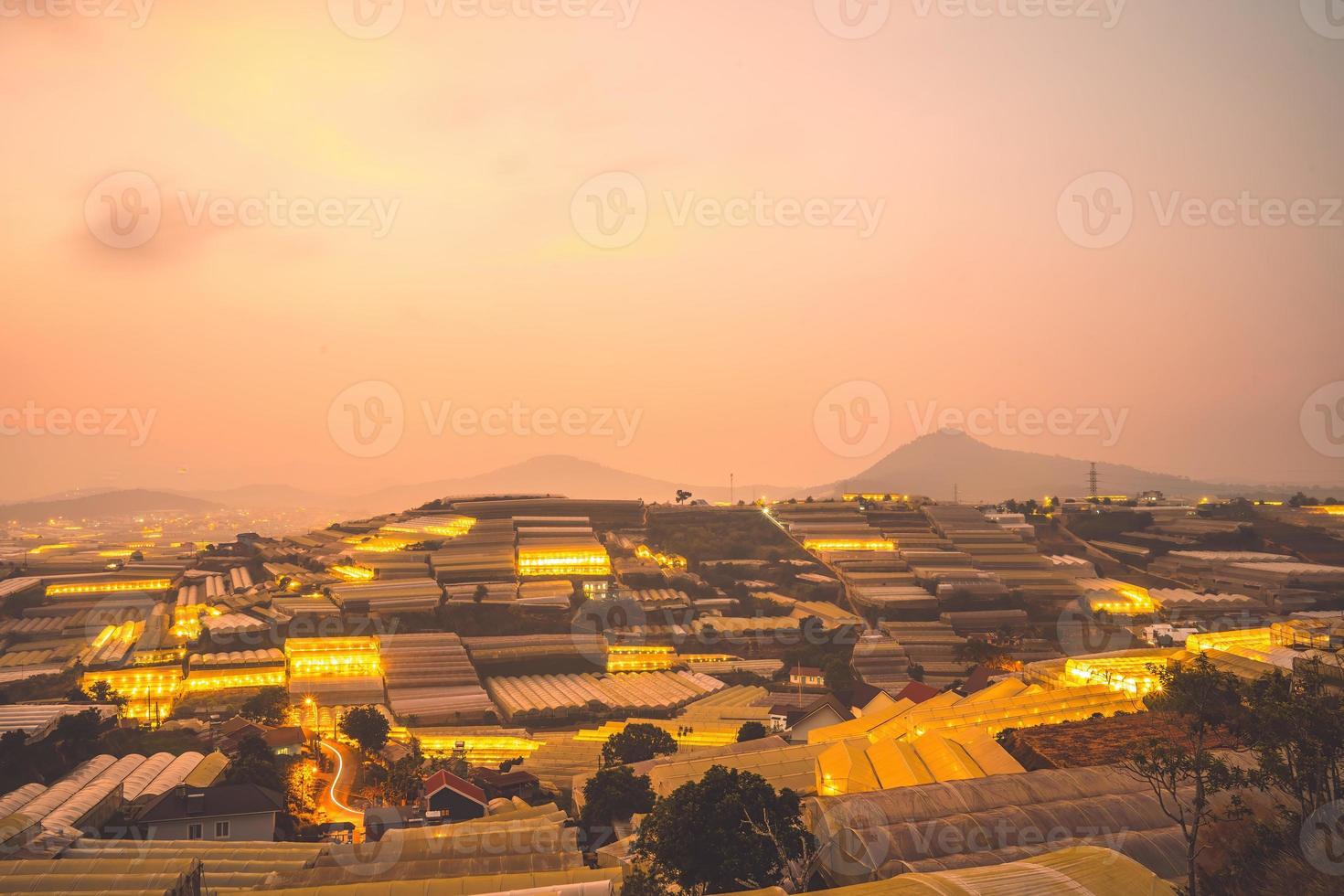 Amazing sunset landscape in agricultural greenhouse valley in Da Lat City. The light from the greenhouse to grow flowers in Da Lat. Travel and landscape concept photo