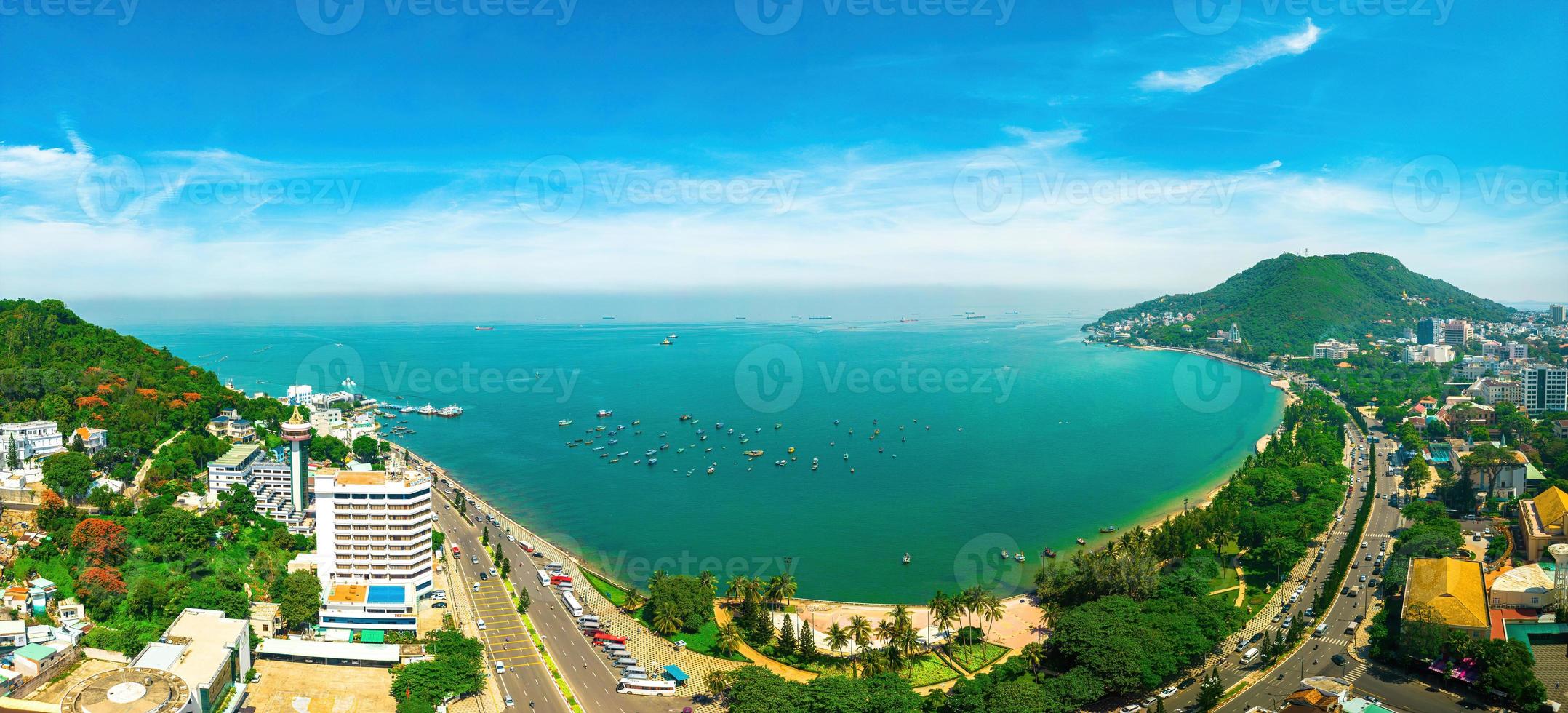 Vung Tau city aerial view with beautiful sunset and so many boats. Panoramic coastal Vung Tau view from above, with waves, coastline, streets, coconut trees and Tao Phung mountain in Vietnam. photo