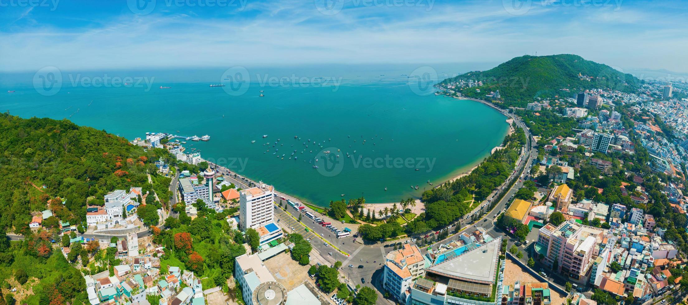Vung Tau city aerial view with beautiful sunset and so many boats. Panoramic coastal Vung Tau view from above, with waves, coastline, streets, coconut trees and Tao Phung mountain in Vietnam. photo