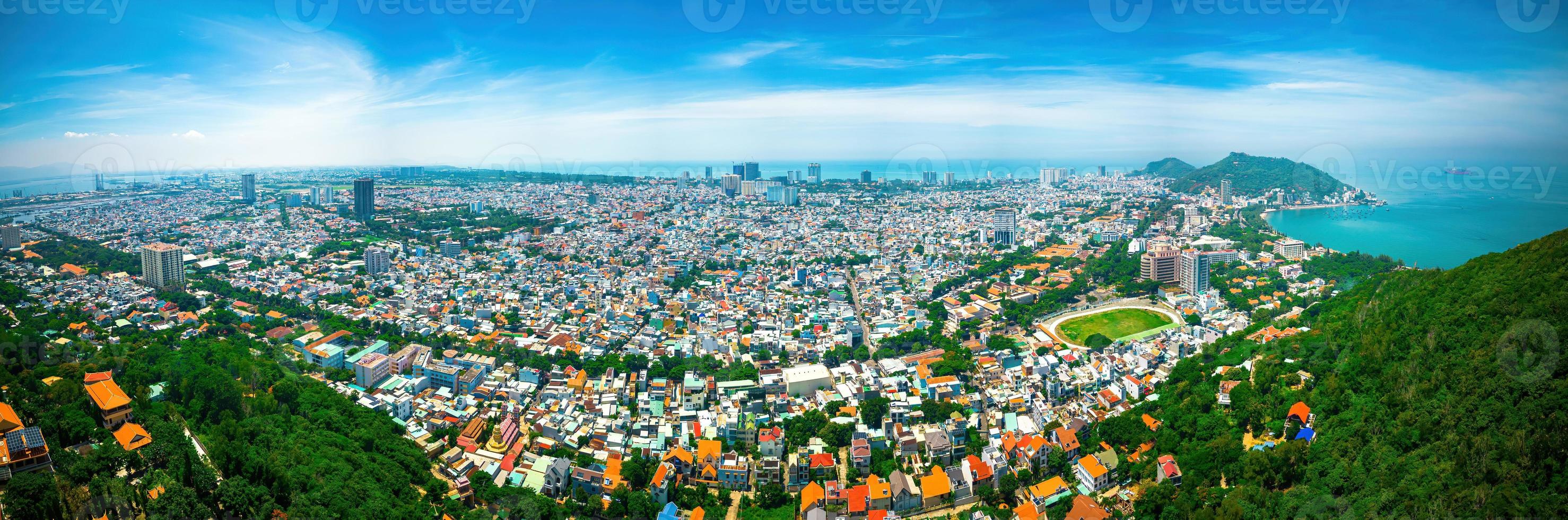 Vung Tau city aerial view with beautiful sunset and so many boats. Panoramic coastal Vung Tau view from above, with waves, coastline, streets, coconut trees and Tao Phung mountain in Vietnam. photo