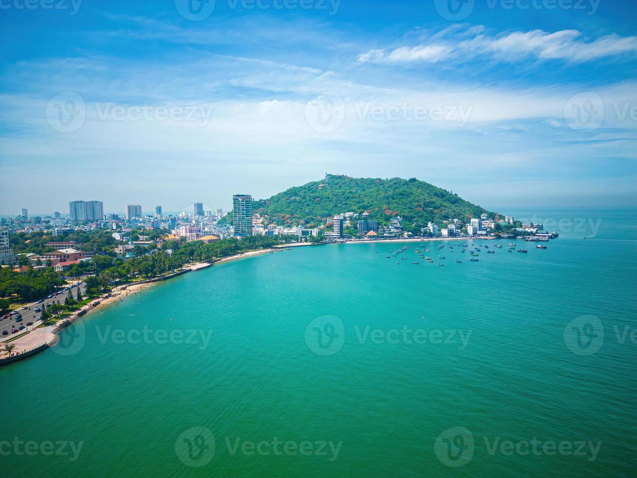 Vung Tau city aerial view with beautiful sunset and so many boats. Panoramic coastal Vung Tau view from above, with waves, coastline, streets, coconut trees and Tao Phung mountain in Vietnam. photo