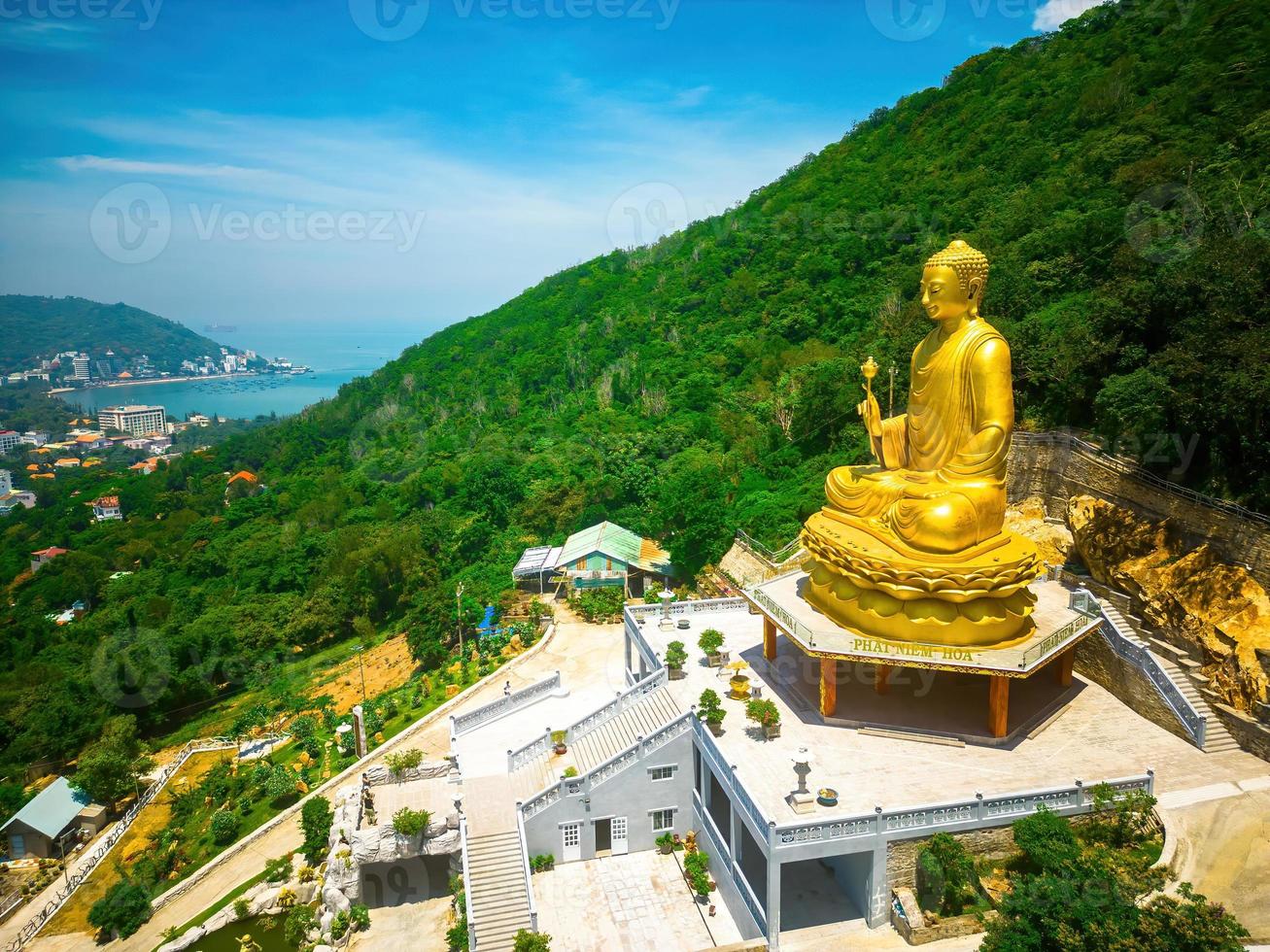 ariel ve la mano de la estatua dorada de buda sosteniendo el loto en el monasterio de chon khong, que atrae a los turistas a visitar espiritualmente los fines de semana en vung tau, vietnam. concepto de viaje foto