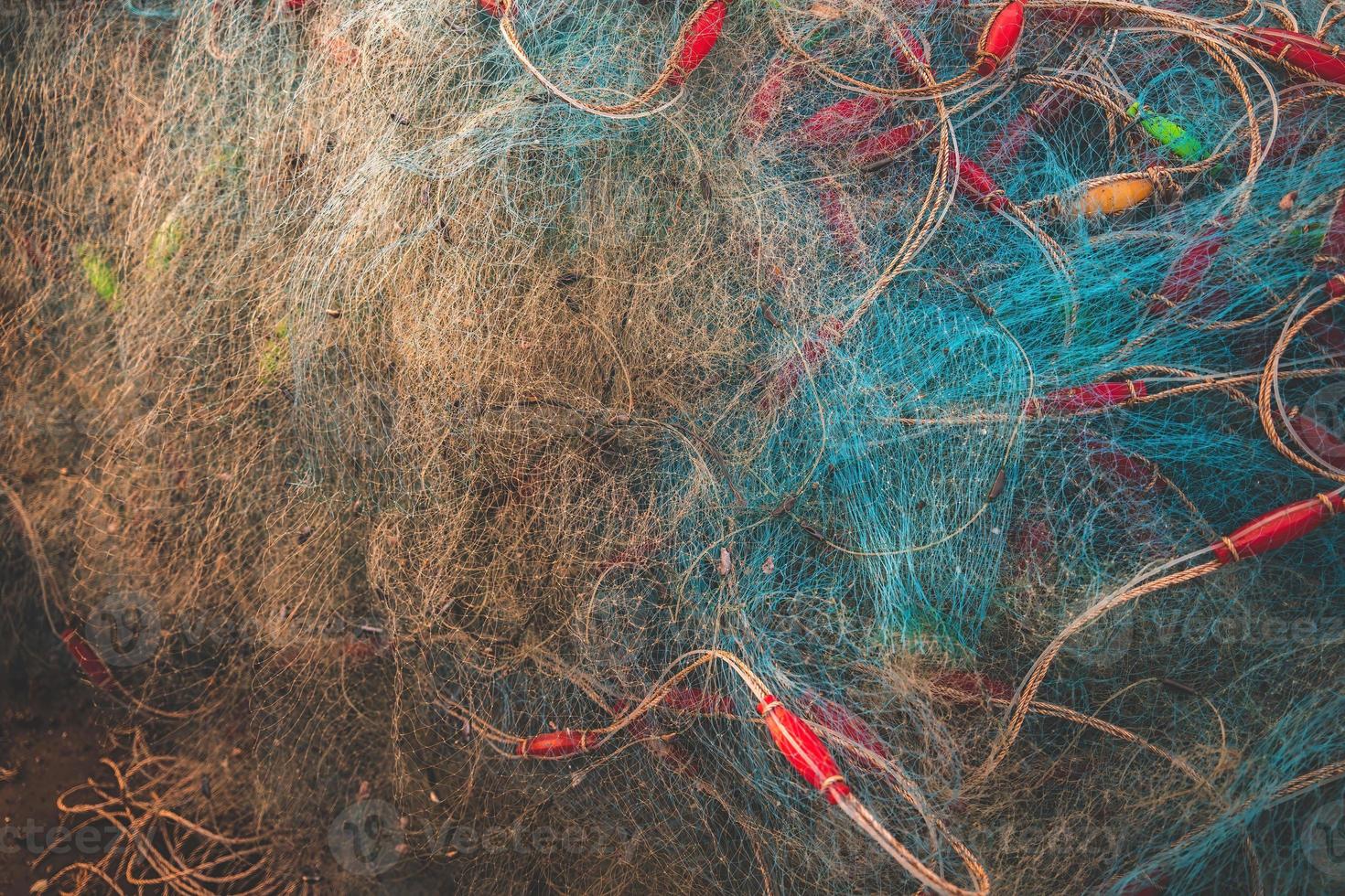 Sea nets - fishing equipment or tackle as texture backdrop with natural sunlight and shadow. Blue textured background of fishing nets close-up, marine design for craft of fishermen. photo