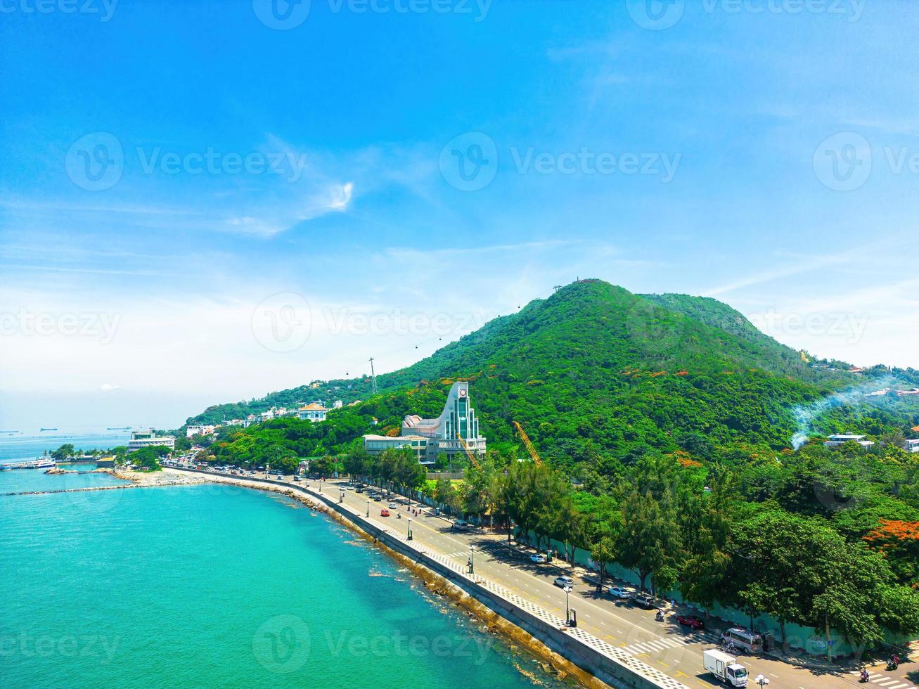 Vung Tau city aerial view with beautiful sunset and so many boats. Panoramic coastal Vung Tau view from above, with waves, coastline, streets, coconut trees and Tao Phung mountain in Vietnam. photo