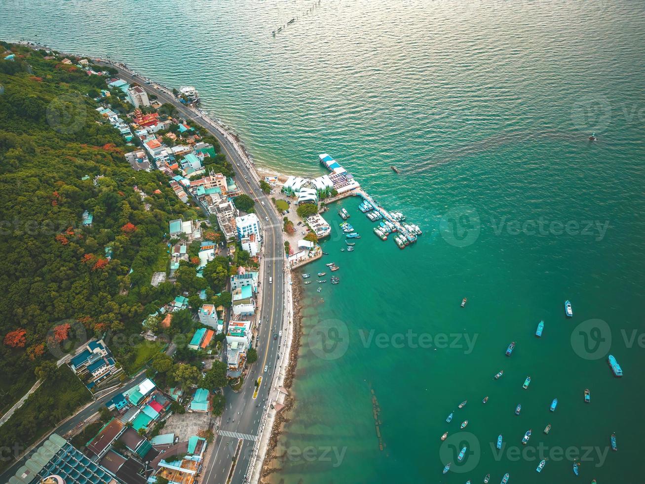 Vung Tau city aerial view with beautiful sunset and so many boats. Panoramic coastal Vung Tau view from above, with waves, coastline, streets, coconut trees and Tao Phung mountain in Vietnam. photo