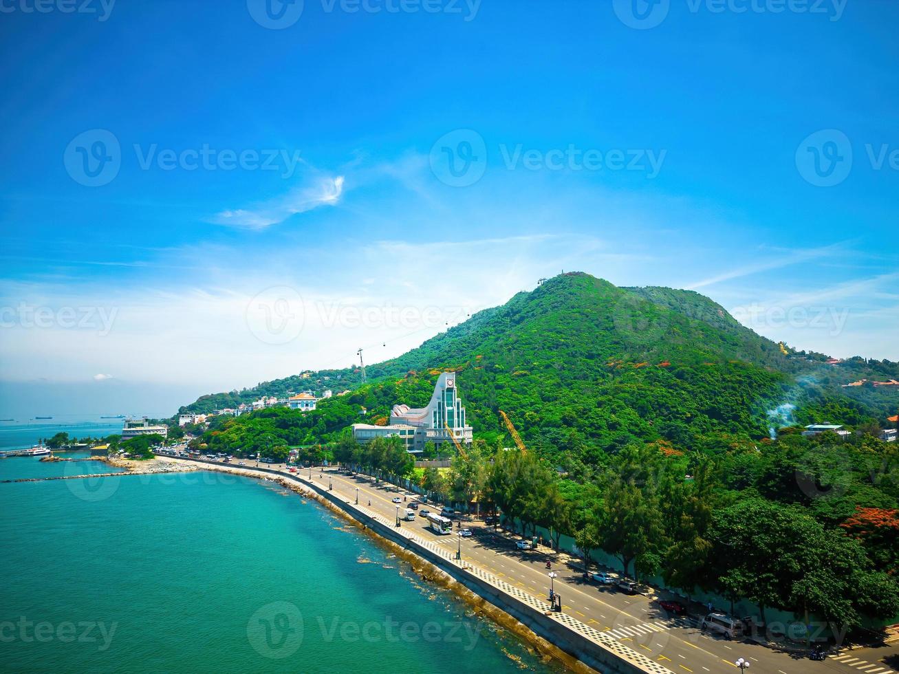 Vung Tau city aerial view with beautiful sunset and so many boats. Panoramic coastal Vung Tau view from above, with waves, coastline, streets, coconut trees and Tao Phung mountain in Vietnam. photo