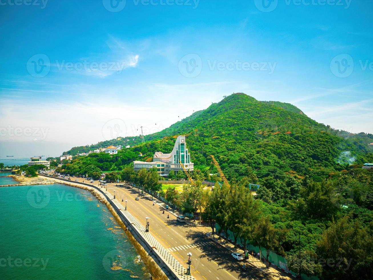 Vung Tau city aerial view with beautiful sunset and so many boats. Panoramic coastal Vung Tau view from above, with waves, coastline, streets, coconut trees and Tao Phung mountain in Vietnam. photo