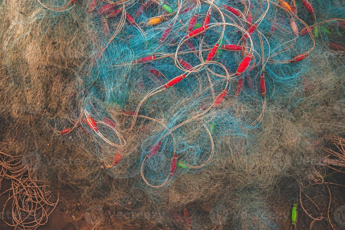 Sea nets - fishing equipment or tackle as texture backdrop with natural sunlight and shadow. Blue textured background of fishing nets close-up, marine design for craft of fishermen. photo