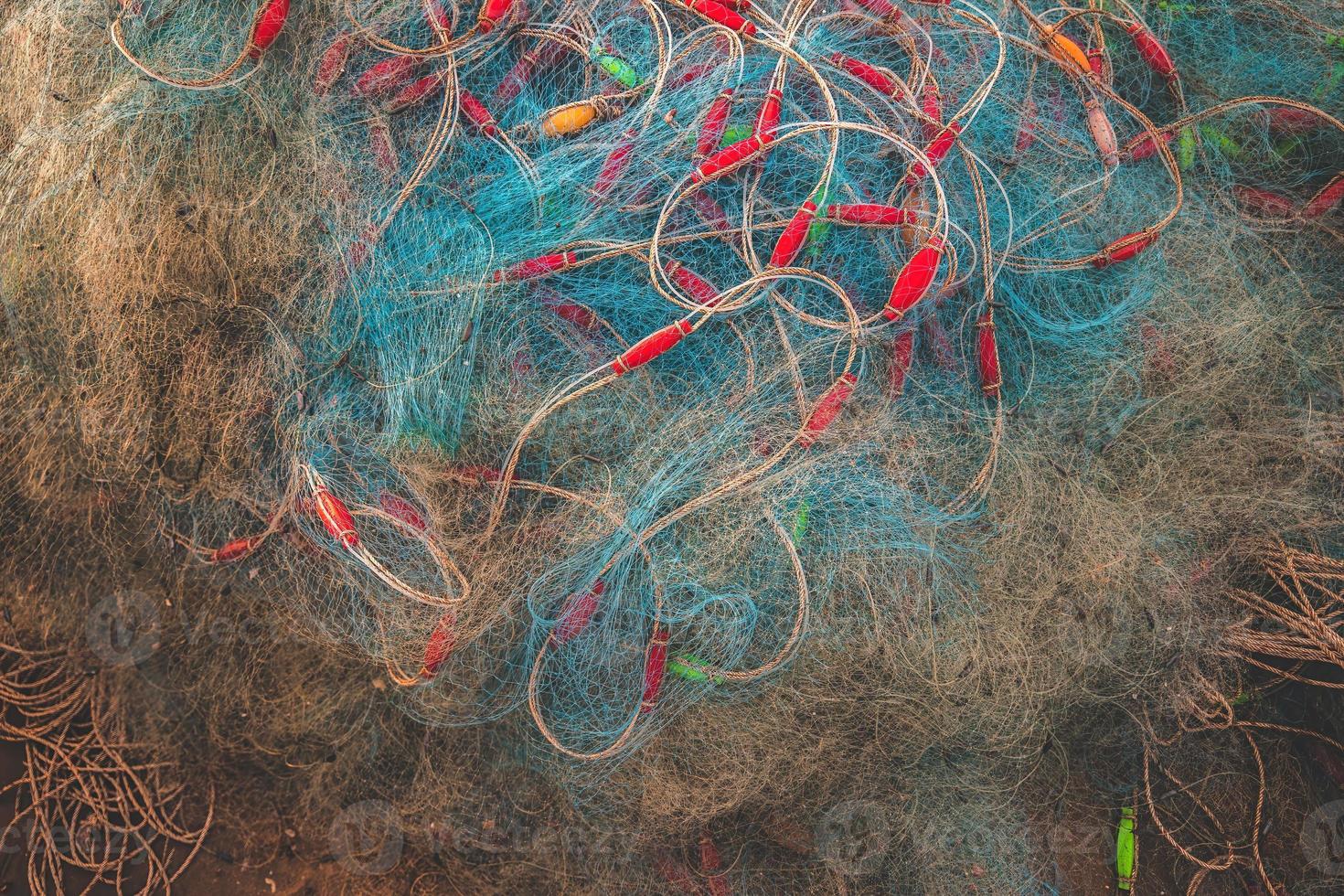 Sea nets - fishing equipment or tackle as texture backdrop with natural sunlight and shadow. Blue textured background of fishing nets close-up, marine design for craft of fishermen. photo