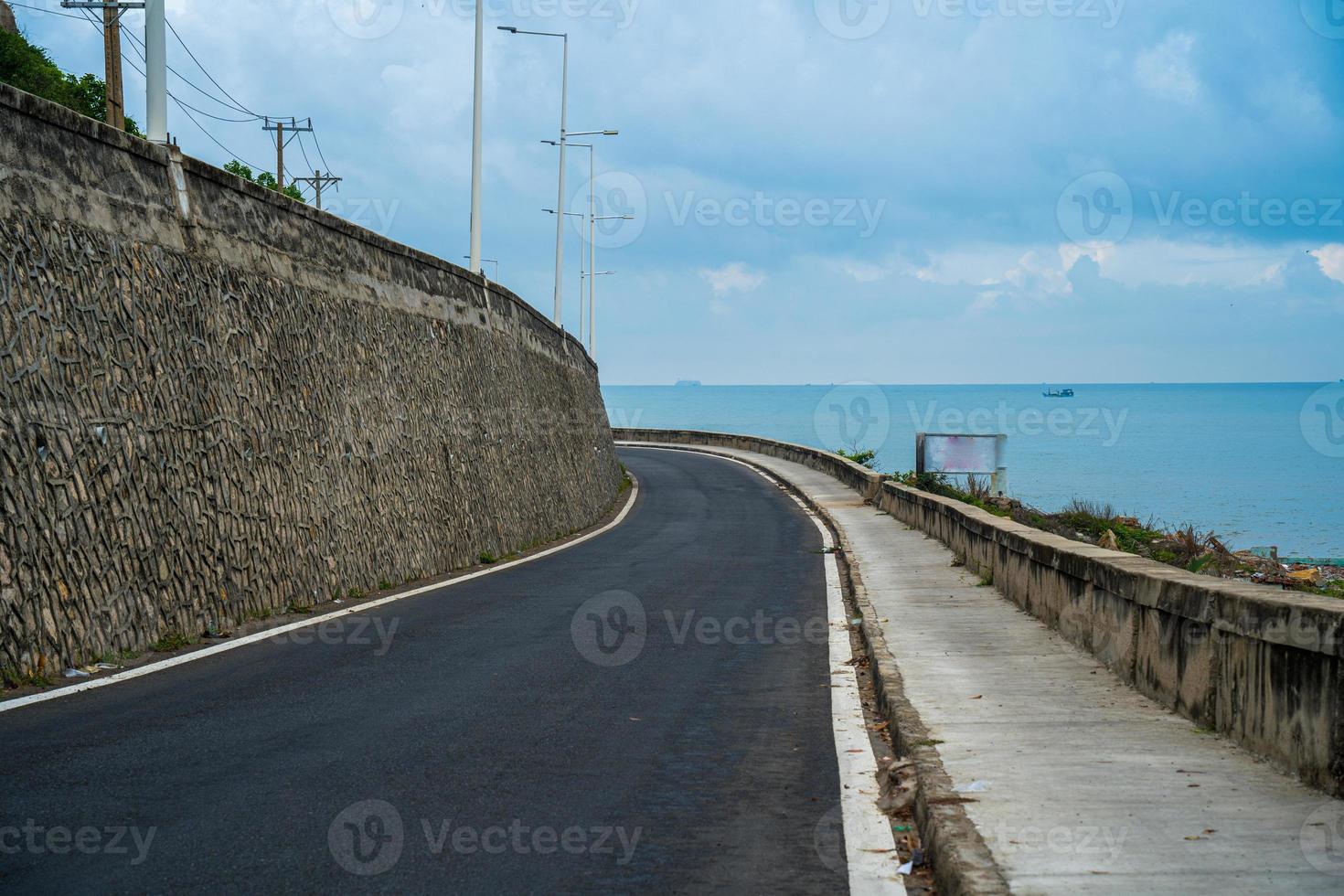 Perfect road trip destination during sunset on an island in Vietnam. Panoramic coastal Long Hai with waves, coastline ,clear sky and road, blue sea and mountain. photo
