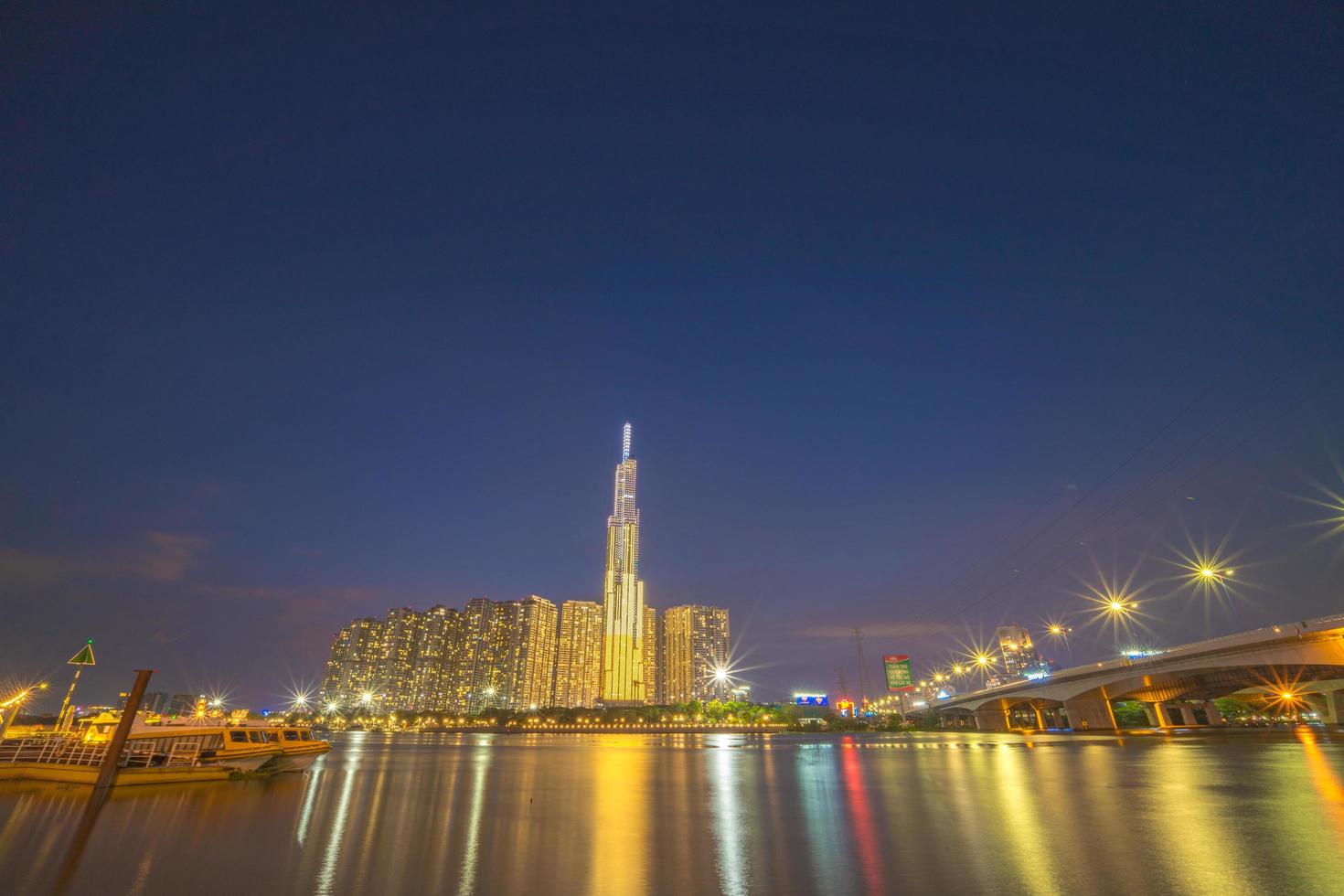 ciudad de ho chi minh, vietnam, 11 de febrero de 2022 vista de la puesta de sol en el punto de referencia 81: es un rascacielos súper alto y un puente de saigón con edificios de desarrollo a lo largo del río saigón, la luz se suaviza foto