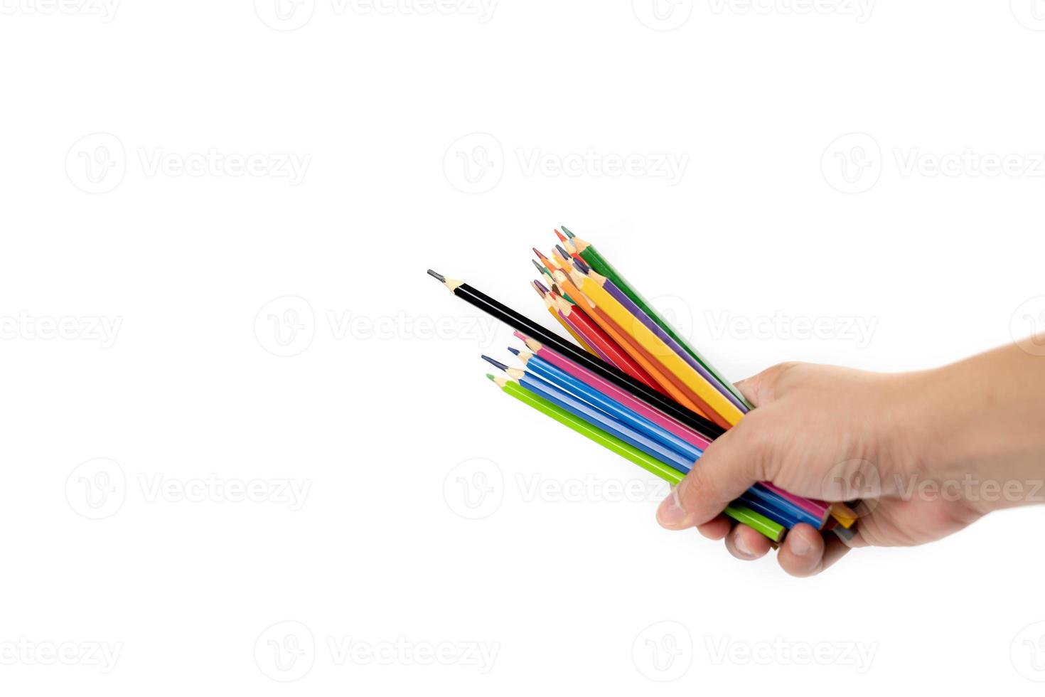 la mano de un hombre asiático sostiene muchos lápices de colores en la mano, encabezados por un lápiz de color negro sobre el fondo blanco. camino de recortes foto