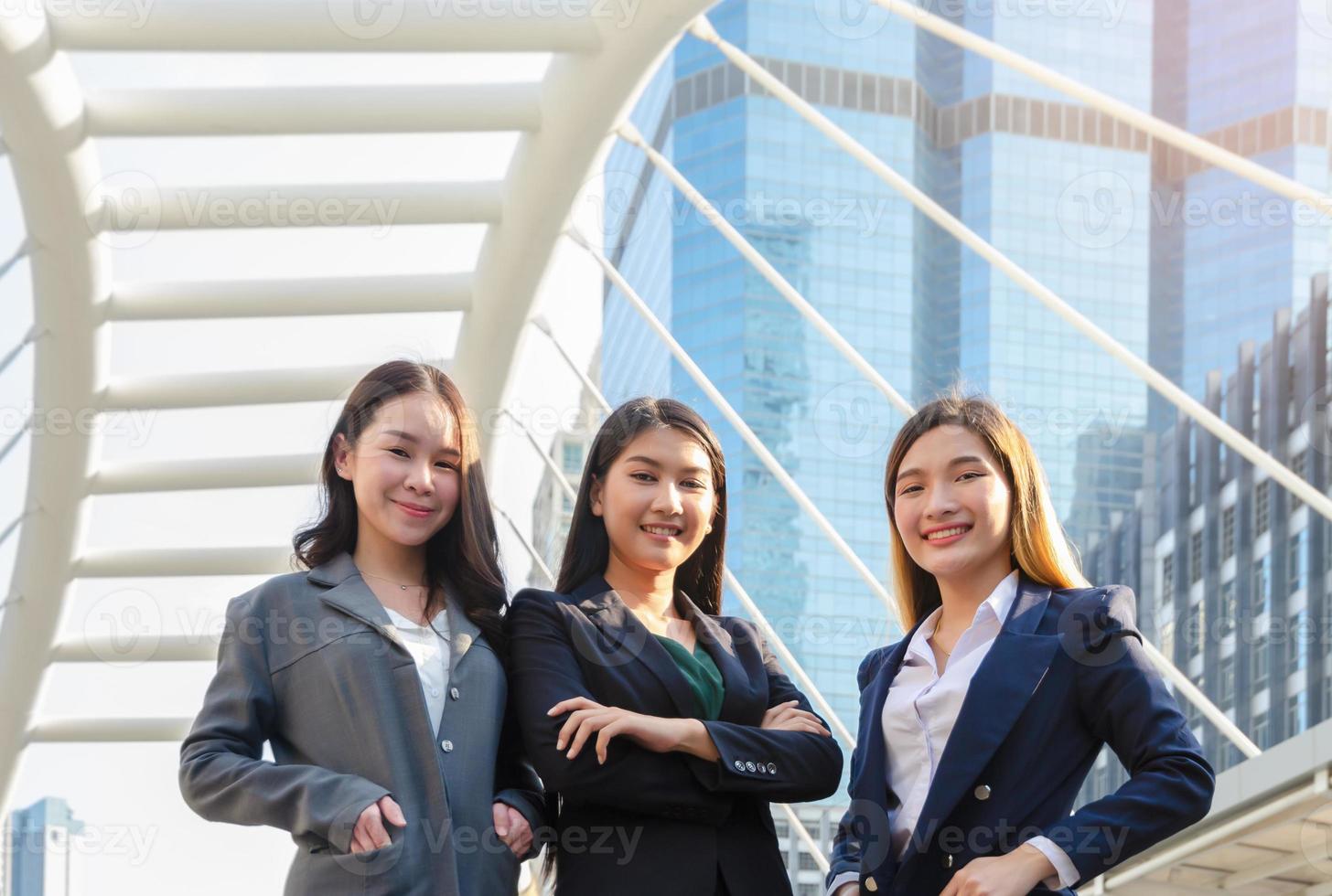 exitosa mujer de negocios con traje de oficina, parada afuera del edificio de oficinas y mirando la cámara. concepto de equipo de negocios foto