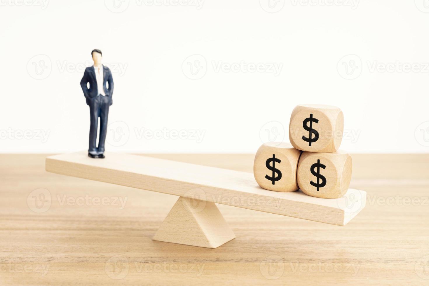 Life and Work or money balance concept. Businessman figurine and dollar symbol on wooden blocks on wooden seesaw photo