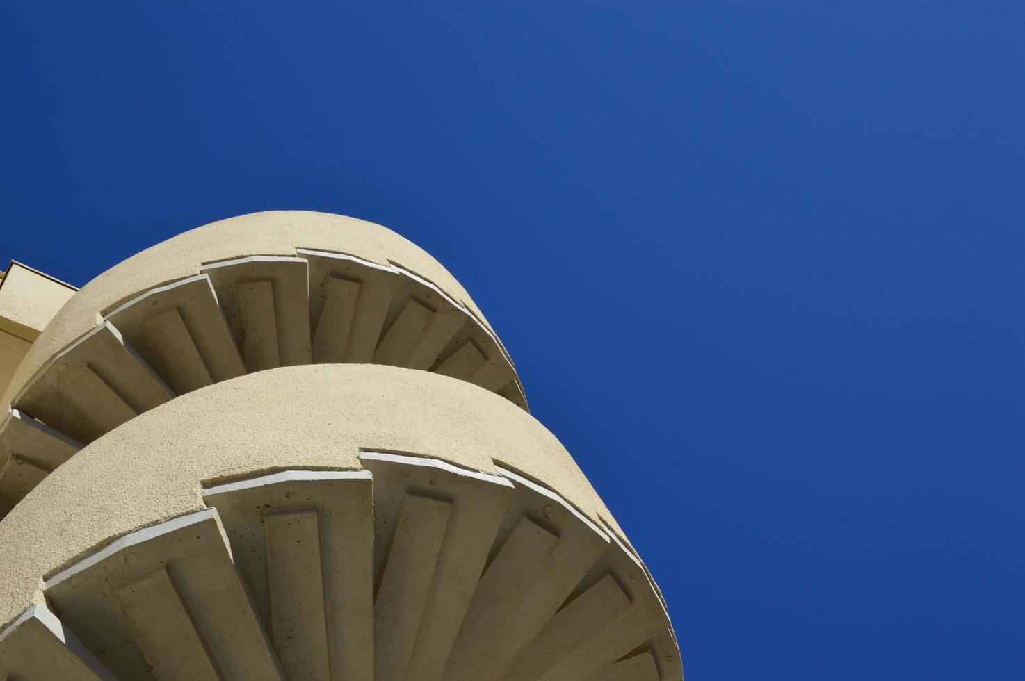 escalera de caracol con fondo de cielo azul foto
