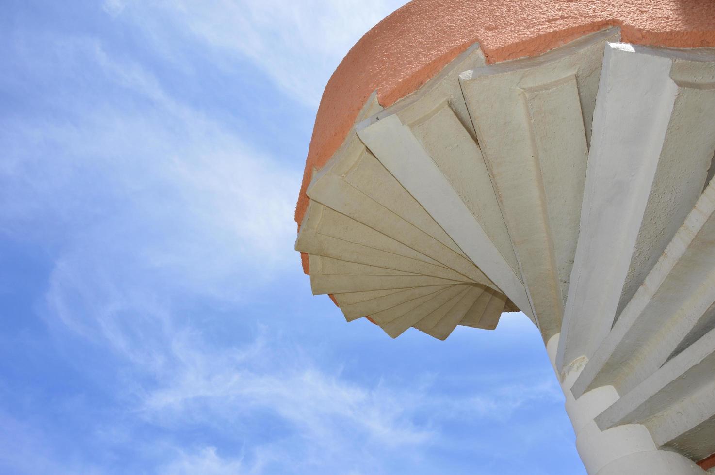 escalera de caracol con fondo de cielo azul foto