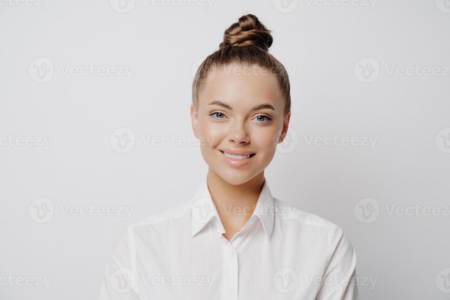 Happy successful business woman in white shirt posing in studio photo