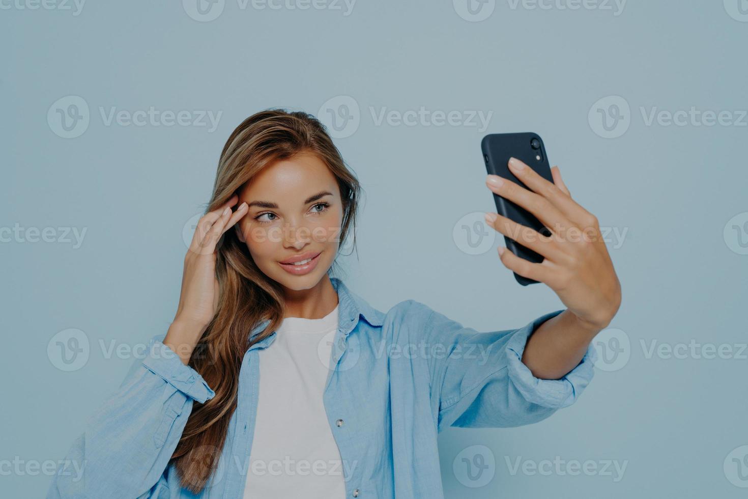 Gorgeous model making selfie on mobile phone photo
