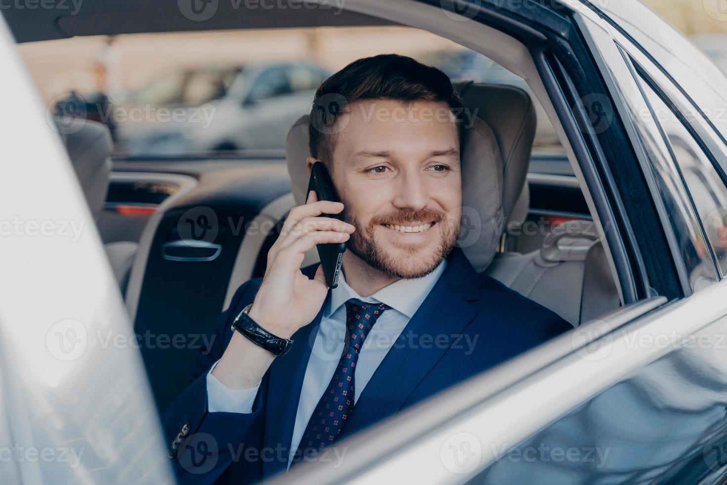 Company manager hearing good news over phone in car photo