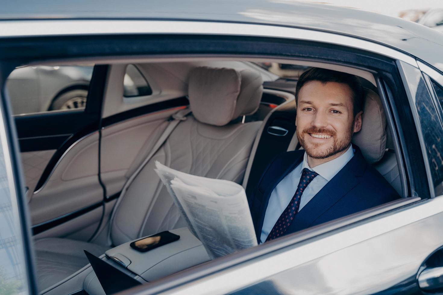 Independent business owner reading newspaper in car photo