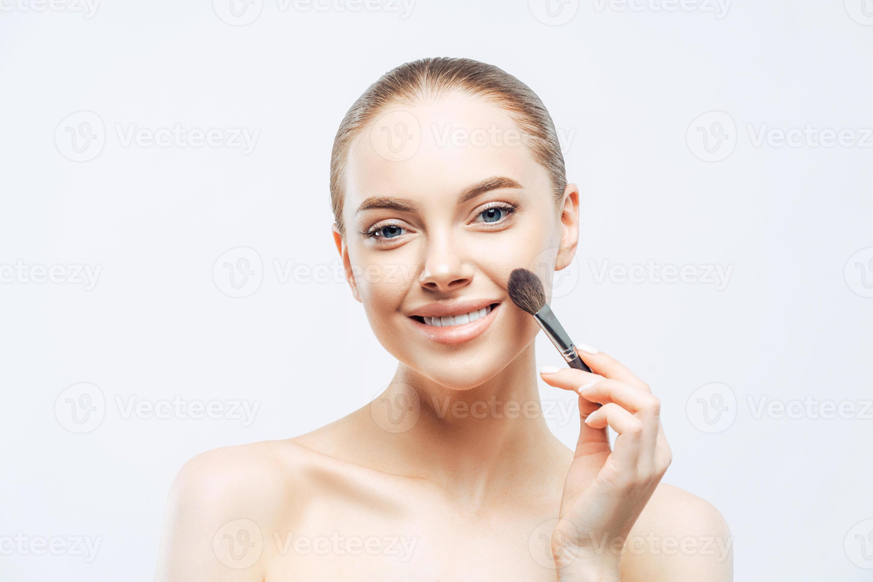 Adorable young brunette woman applies cosmetic tonal foundation with ...