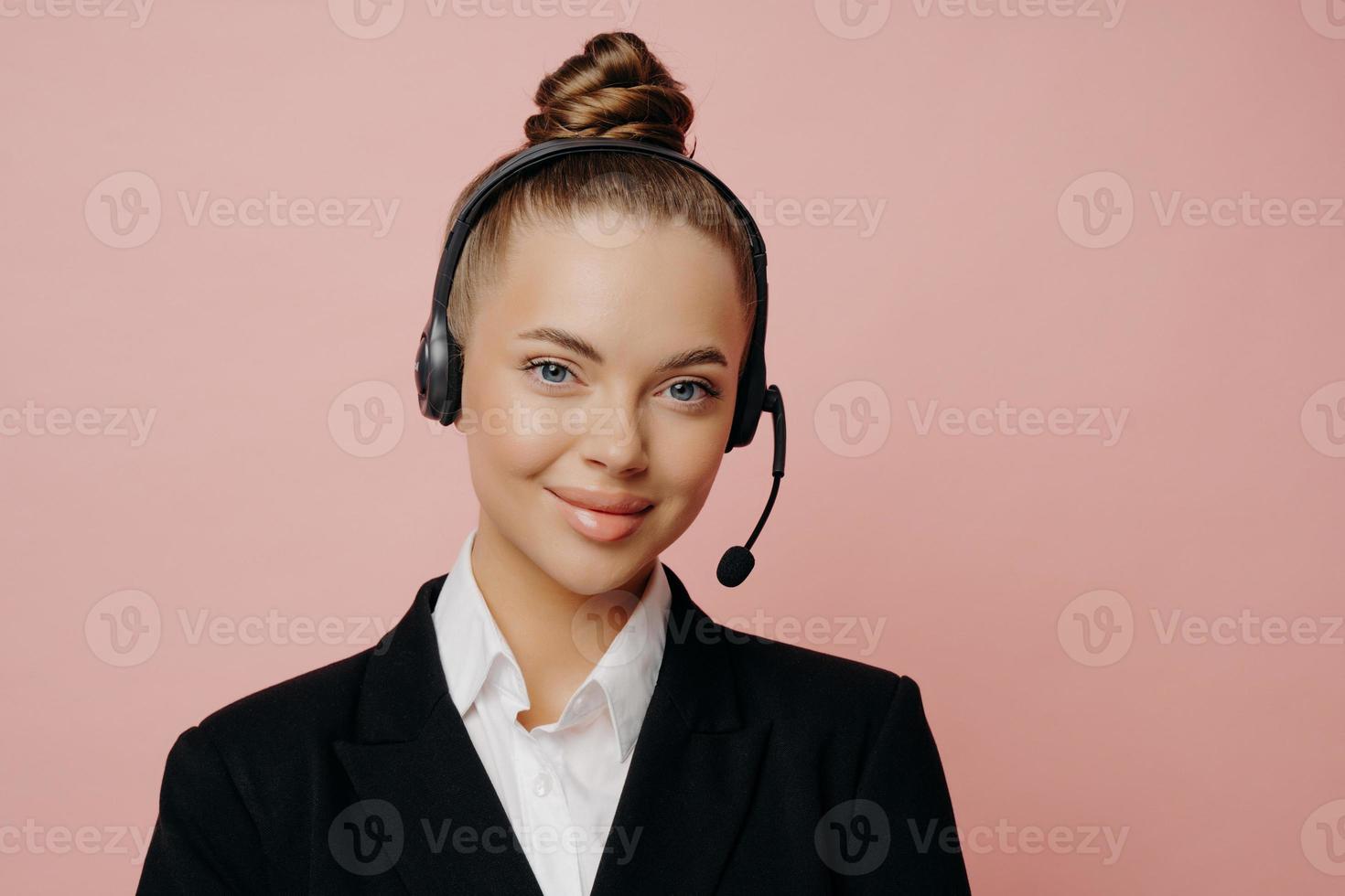 Pretty business lady in headset being happy and satisfied after online meeting photo