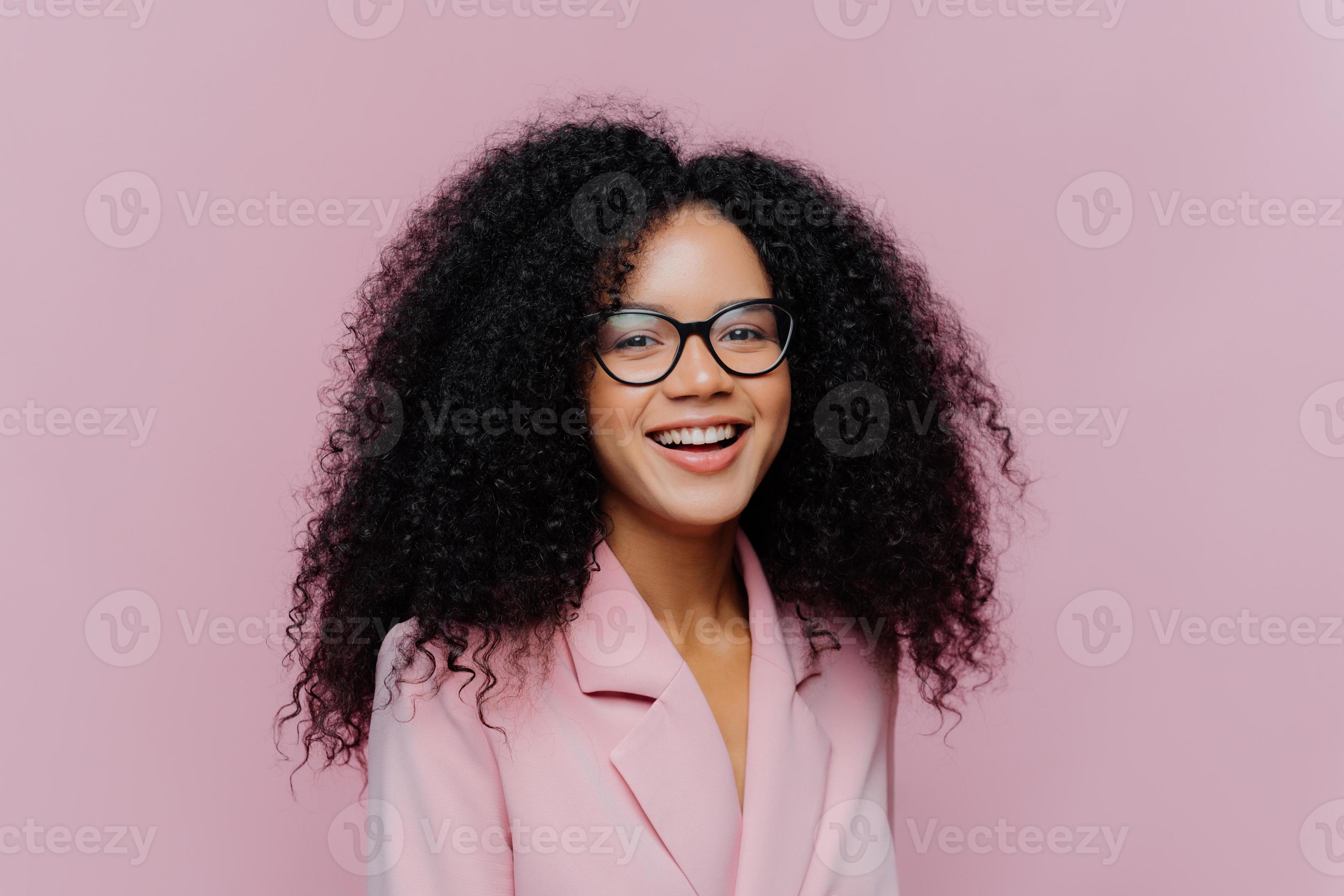 Positive curly haired businesswoman wears spectacles, formal wear, has  bushy hairstyle, being in good mood after successful day at work, poses  against violet background. Monochrome. Happy director 8359140 Stock Photo  at Vecteezy