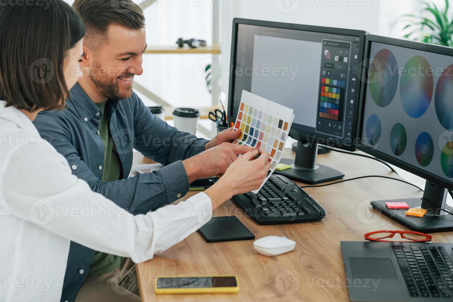 elegir los colores correctos. dos diseñadores trabajando juntos en la oficina foto