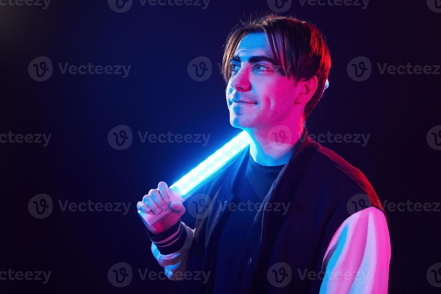 Side view. Man standing in the studio with neon light photo