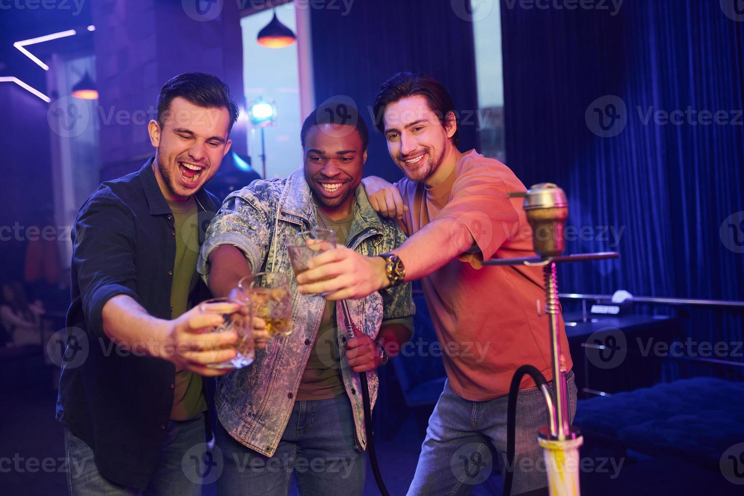 Partying all night long. Group of friends having fun in the night club together photo