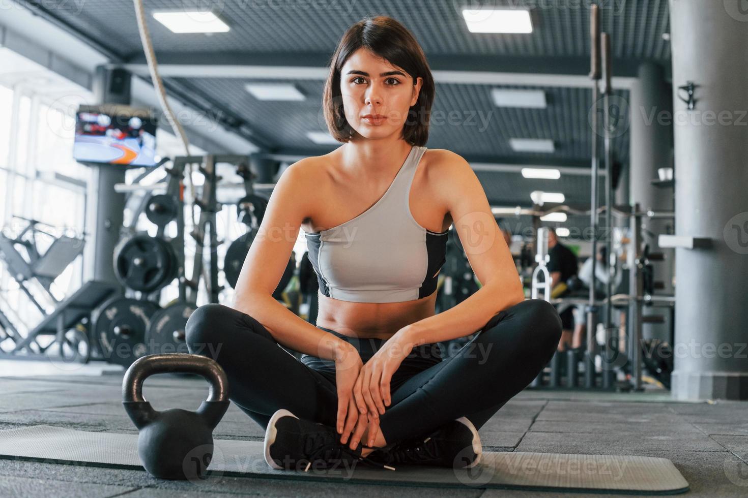 Woman in sportive clothes with slim body type is in the gym