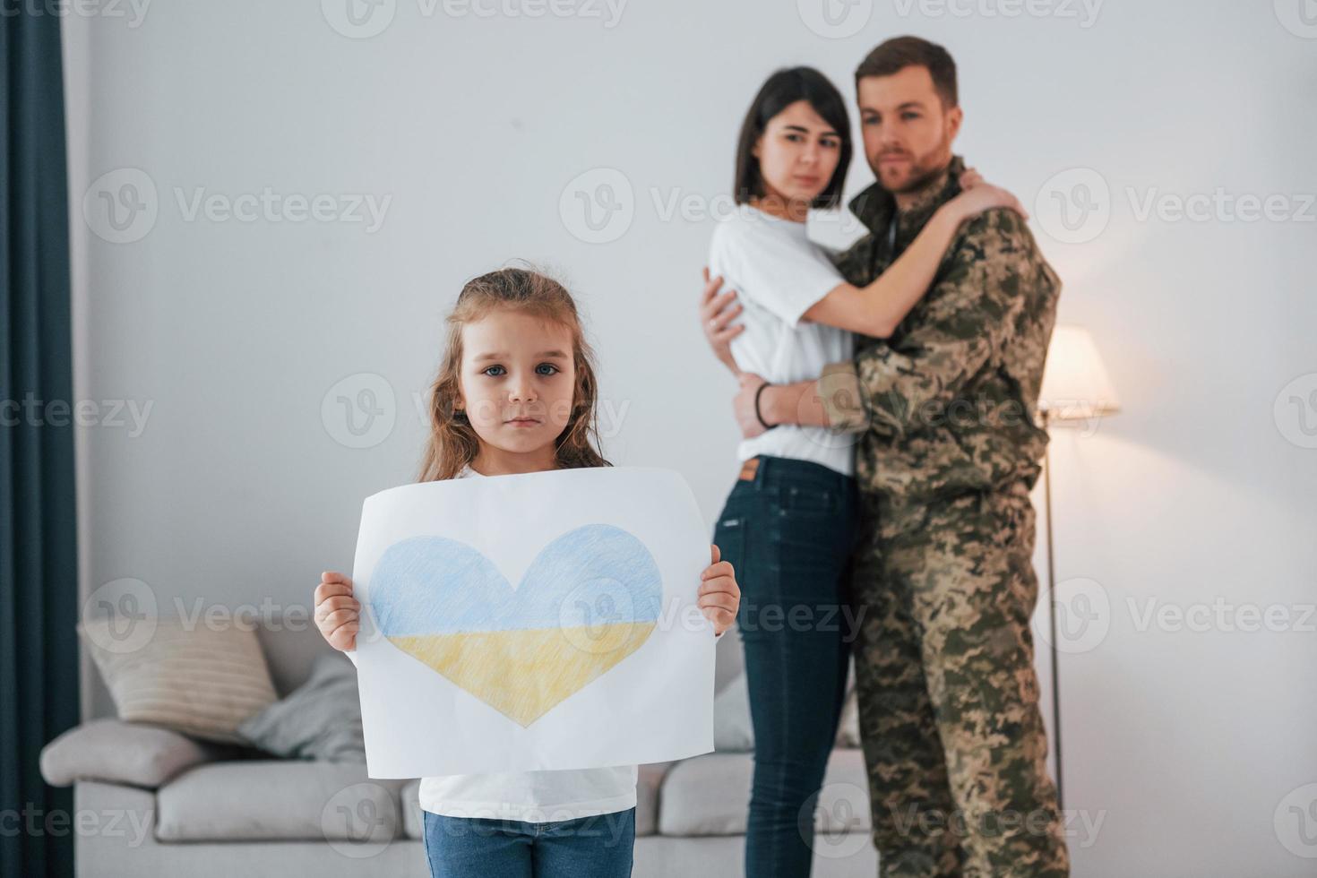 Stop war in Ukraine conception. Soldier in uniform is at home with his wife and daughter photo