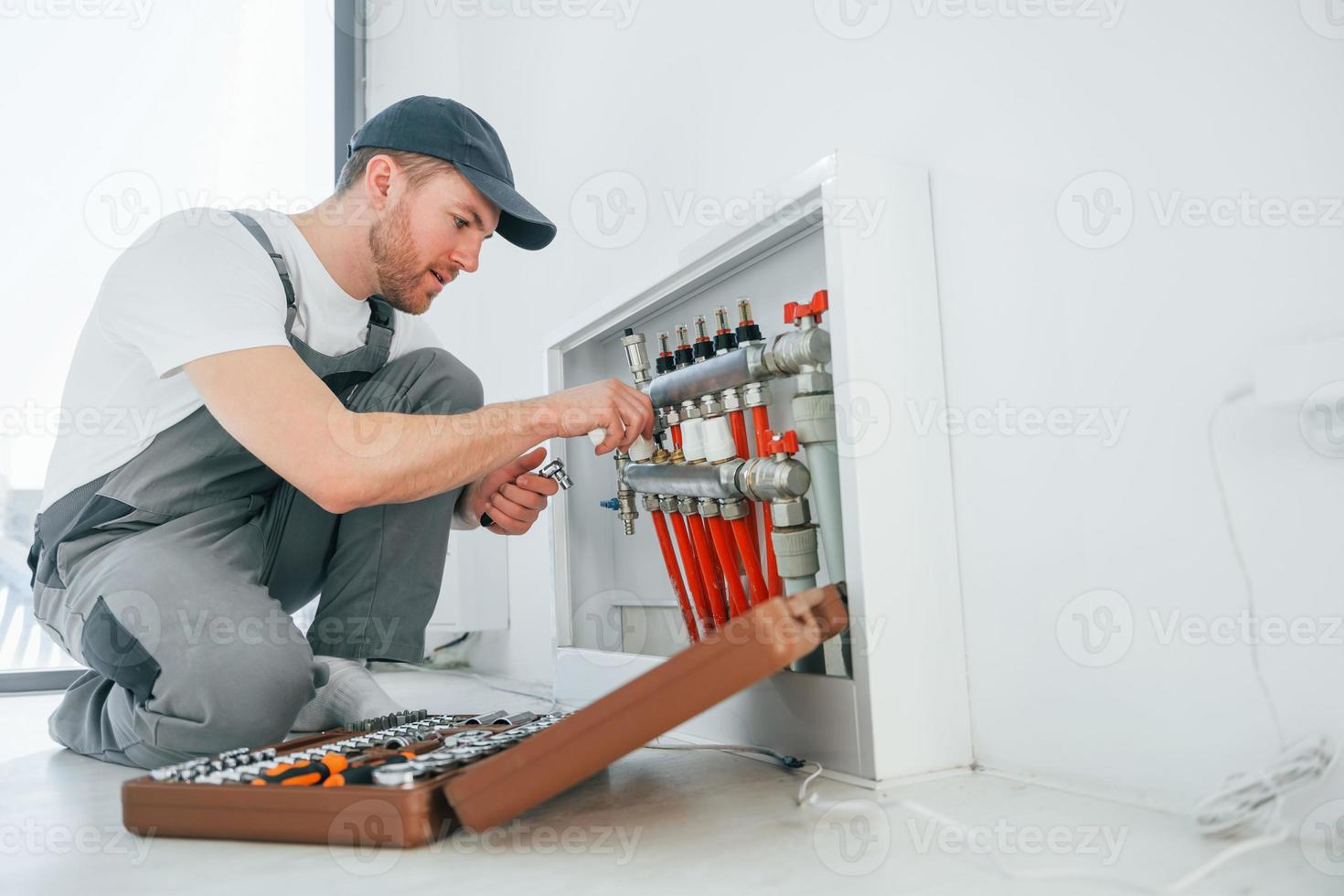 With special tools. Repairman is working indoors in the modern room photo