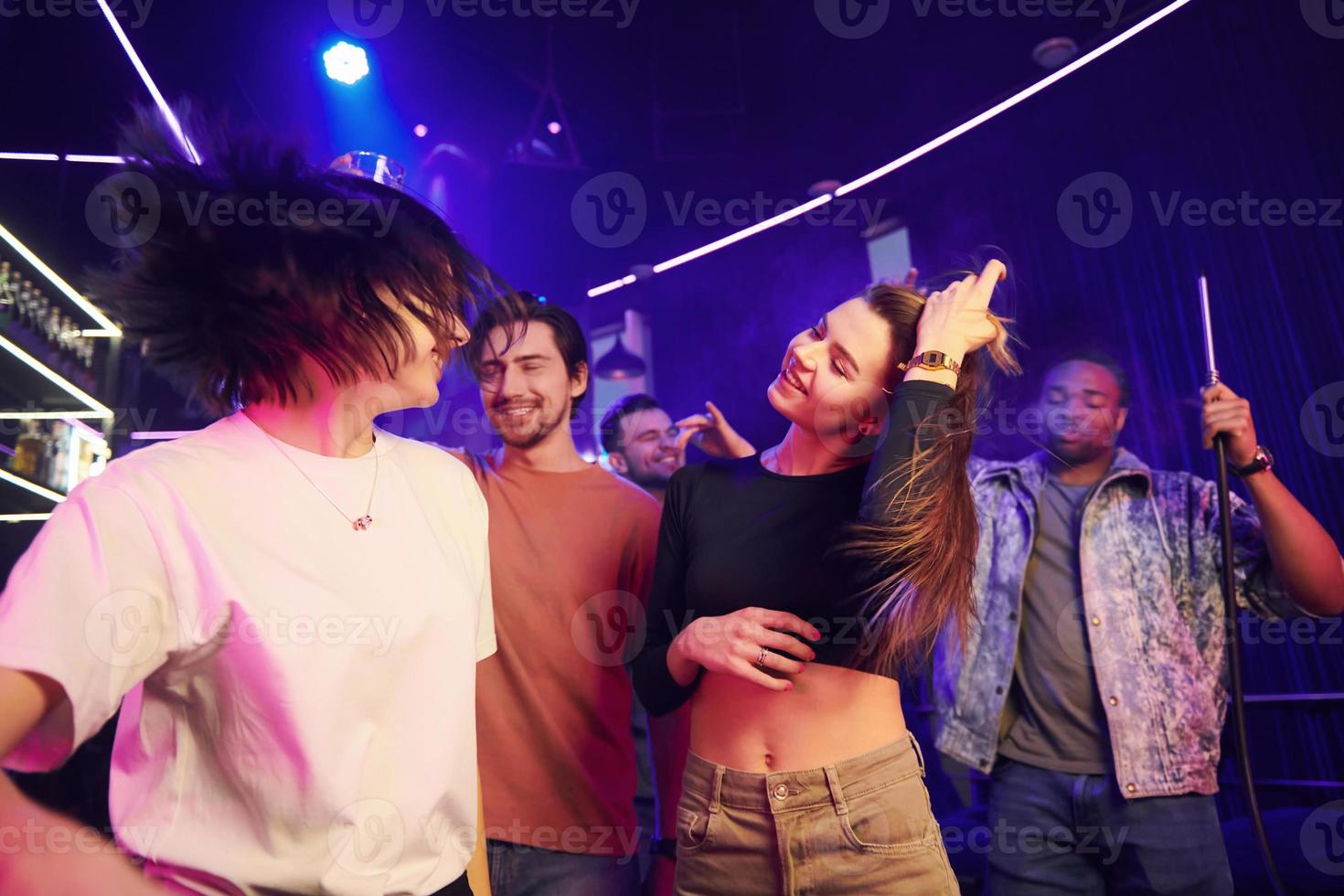 Having a party. Group of friends in the night club together photo